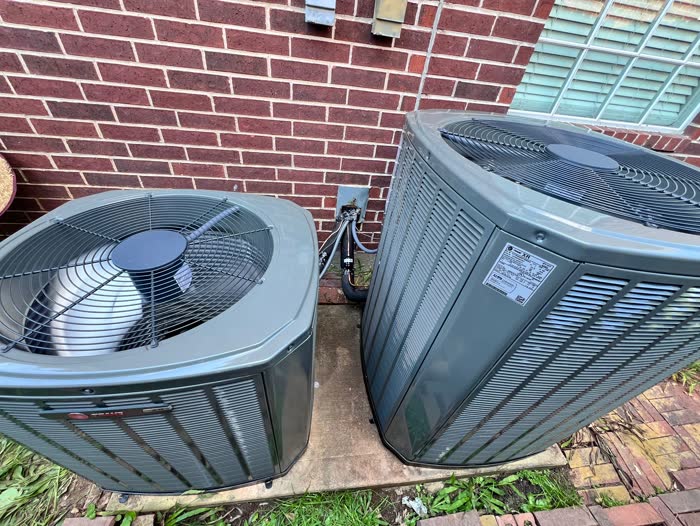 Two well-maintained AC condenser units running at a Houston home